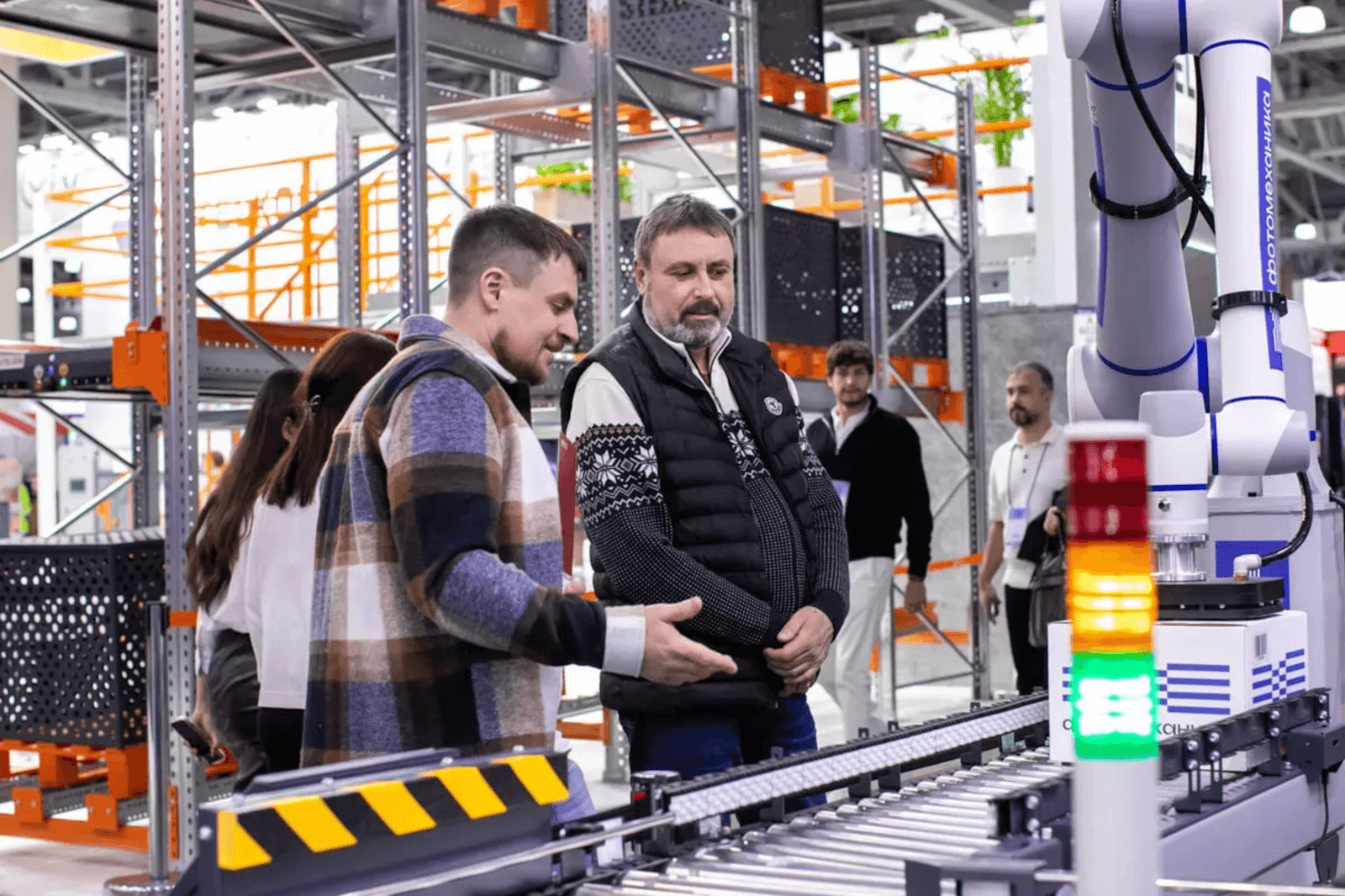 Operators watching an automated conveyor line inside a warehouse